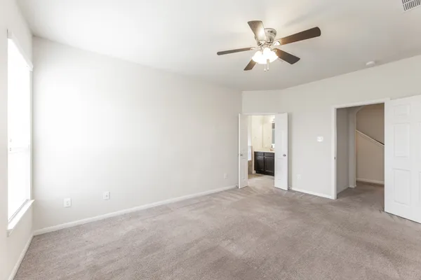 a view of an empty room with a ceiling fan