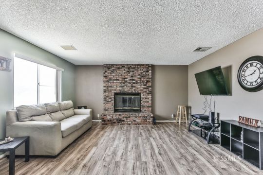 604 South Lakeview Court Ridgecrest, CA 93555 - Photo 2 of 29 a living room with furniture a flat screen tv and a fireplace