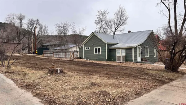 a view of a yard in front of a house with large trees