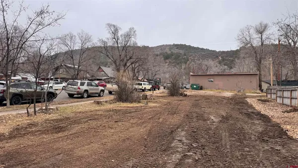 a view of road with card parked on the roadside