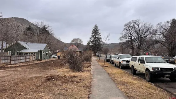 a view of a town with cars parked in front of it