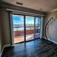 a view of a room with wooden floor and door