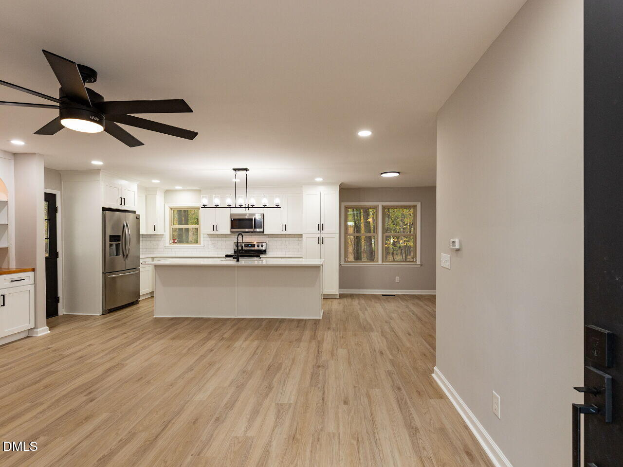 4800 Theys Road Raleigh, NC 27606 - Photo 6 of 43 a large kitchen with stainless steel appliances kitchen island a large counter top and a wooden floors