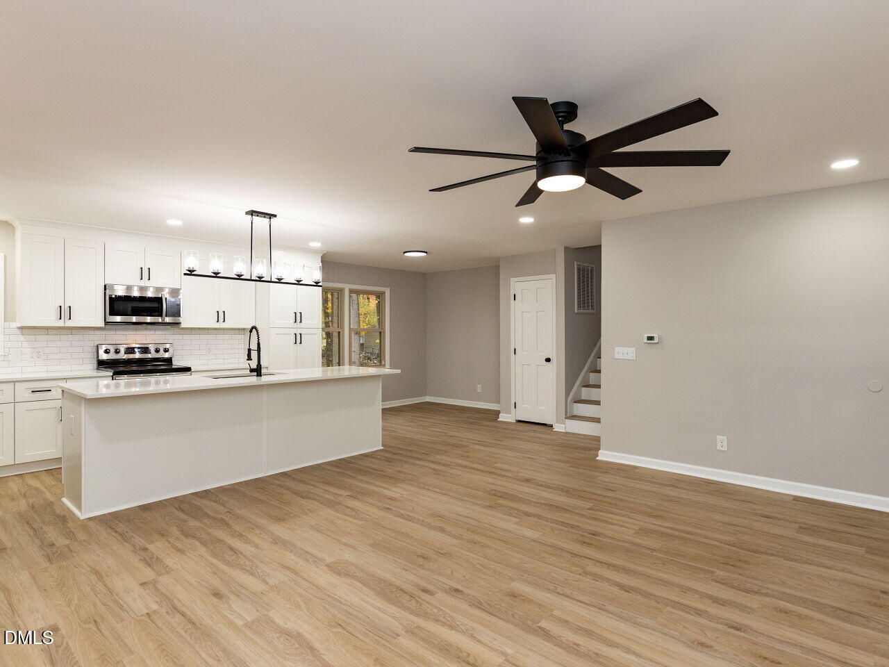 4800 Theys Road Raleigh, NC 27606 - Photo 7 of 43 a large kitchen with stainless steel appliances a large counter top a sink a refrigerator and a stove