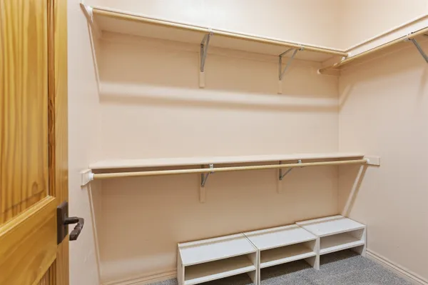 a view of walk in closet with empty racks