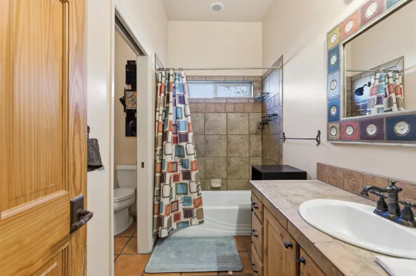 a bathroom with a granite countertop sink a mirror and shower