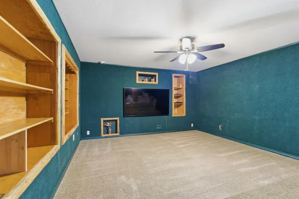 a bedroom with a bed and a ceiling fan