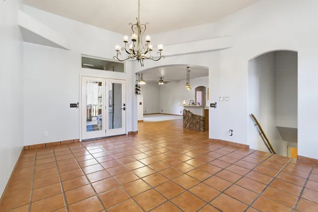 a view of a hallway with wooden floor and a chandelier
