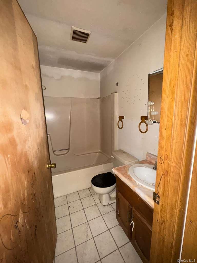 2028 Story Avenue Bronx, NY 10473 - Photo 10 of 16 Bathroom featuring vanity, light tile patterned floors, and washtub / shower combination