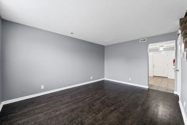 a view of an empty room with wooden floor