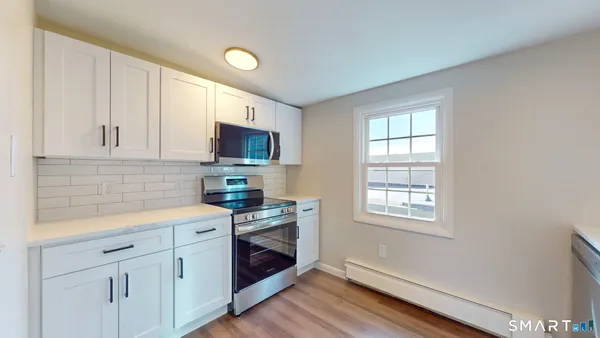 a kitchen with stainless steel appliances white cabinets stove and sink