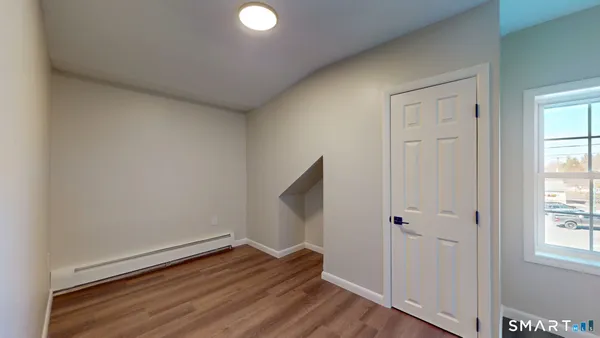 a view of room with window and wooden floor