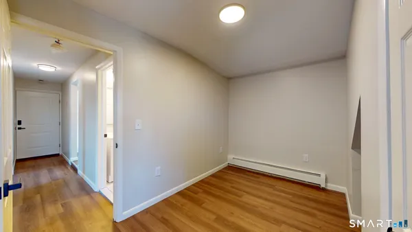 a view of a room with wooden floor and a bathroom