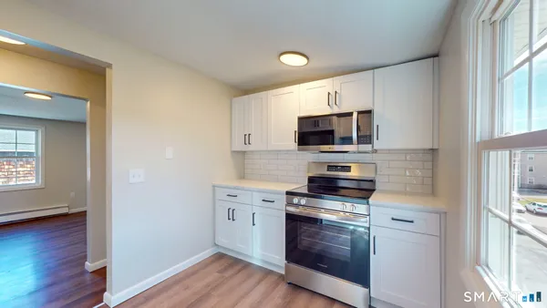 a kitchen with granite countertop a stove and a microwave