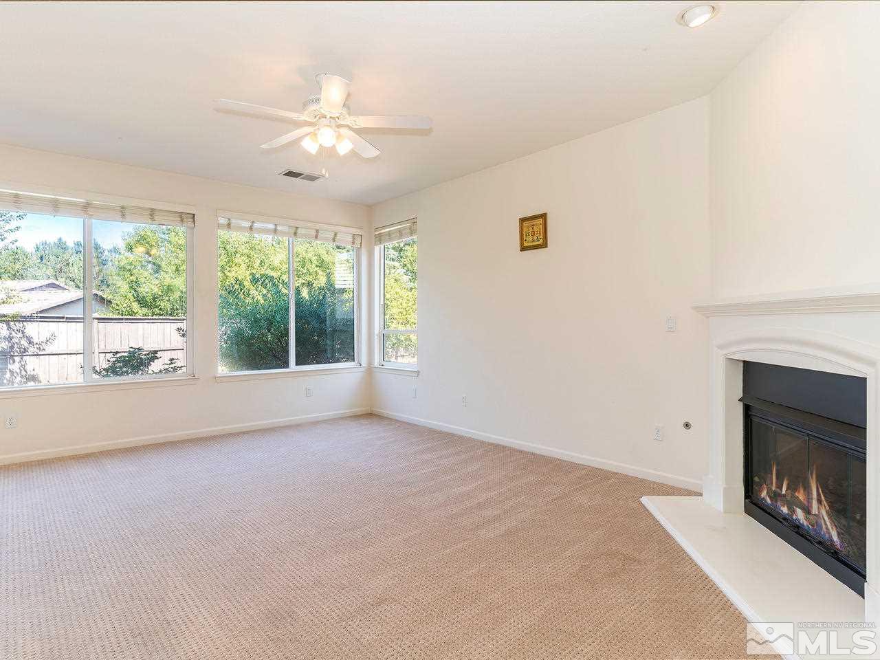 13665 Dressage Court Reno, NV 89521 - Photo 9 of 22 a view of an empty room with wooden floor and a fireplace