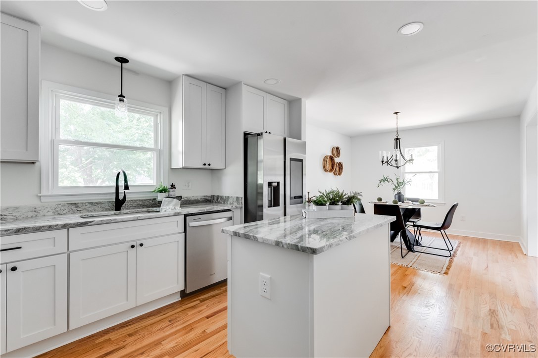 2840 Osborne Road Chester, VA 23831 - Photo 15 of 42 a kitchen with a refrigerator a sink dishwasher a dining table and chairs with wooden floor