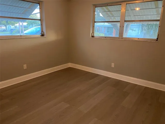 a view of a room that has wooden floor and windows
