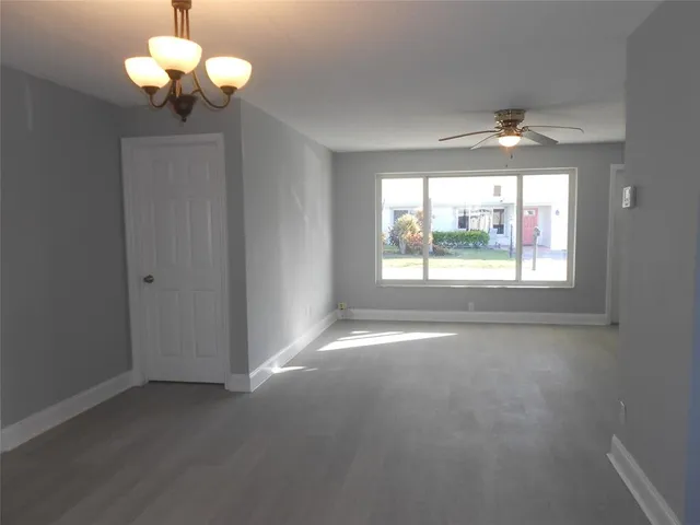 a view of a room with a chandelier fan and windows