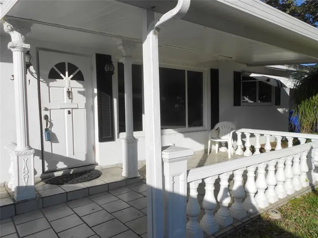 a front view of a house with glass door and furniture
