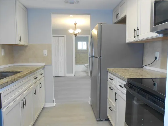 a kitchen with cabinets and a stainless steel refrigerator stove