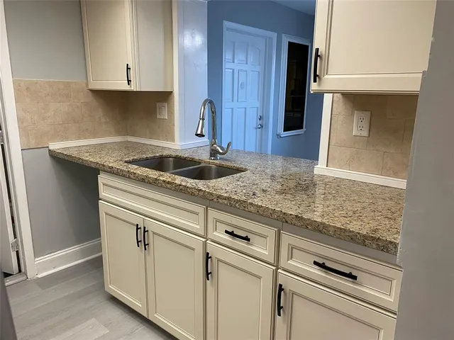 a kitchen with granite countertop white cabinets and white appliances