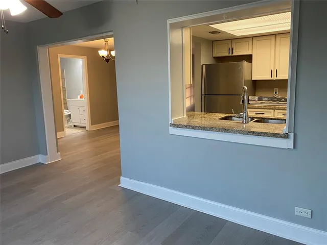 a view of a hallway with wooden floor and a cabinet