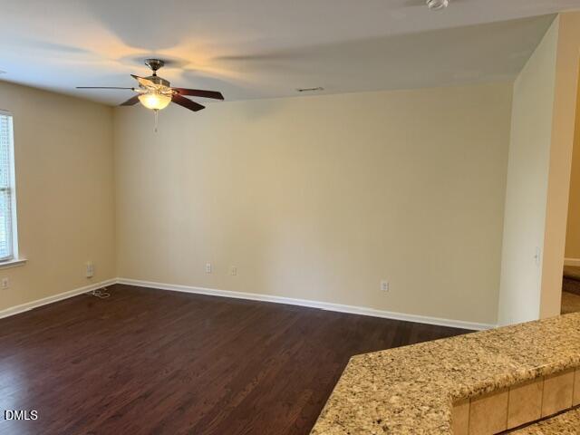8227 Primanti Boulevard Raleigh, NC 27612 - Photo 5 of 25 a view of a room with wooden floor and a ceiling fan