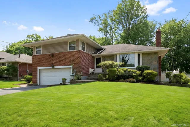 a front view of a house with a yard and trees