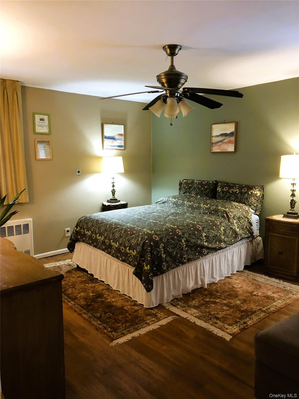 24 Cedar Road Westbury, NY 11590 - Photo 12 of 21 Bedroom 3 featuring dark wood finished floors, radiator, and a ceiling fan