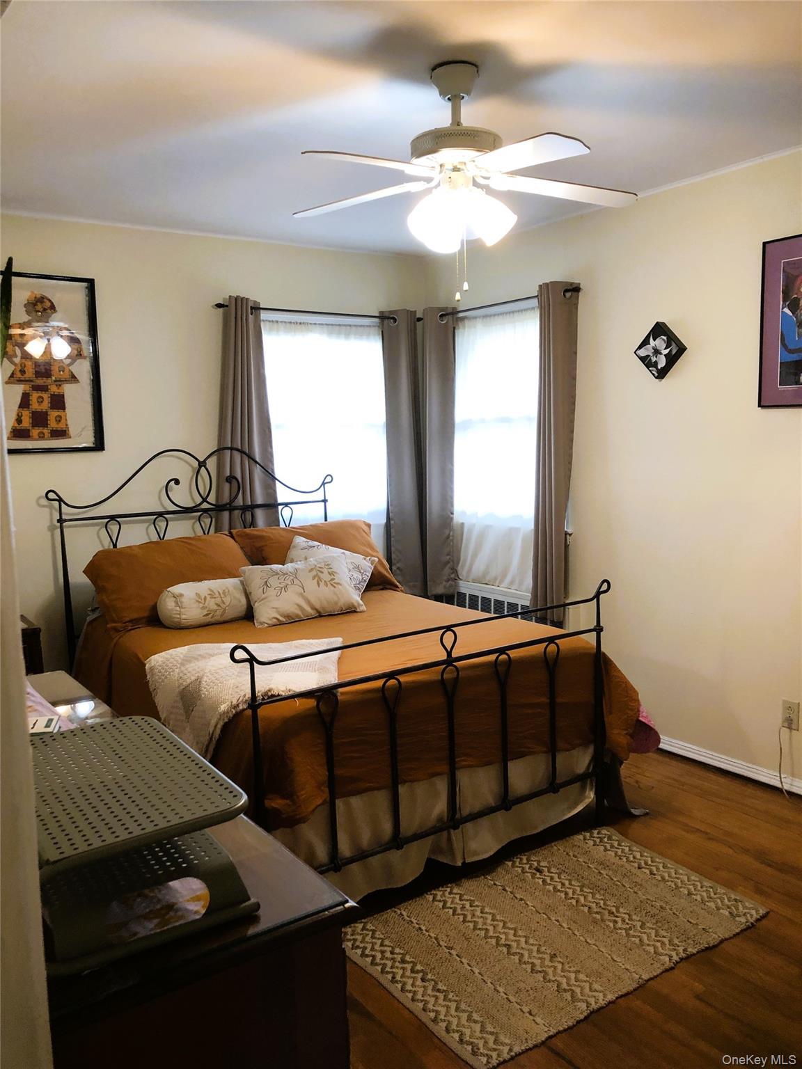 24 Cedar Road Westbury, NY 11590 - Photo 13 of 21 Bedroom 1 with dark wood finished floors and a ceiling fan
