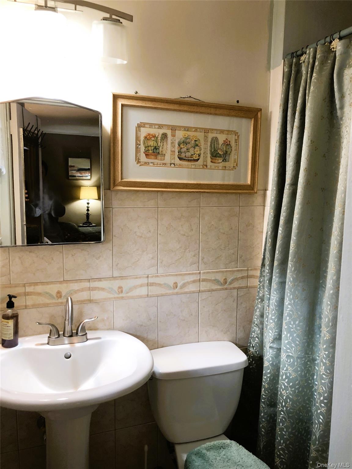 24 Cedar Road Westbury, NY 11590 - Photo 18 of 21 Full bathroom featuring tile walls, a shower with shower curtain, and backsplash