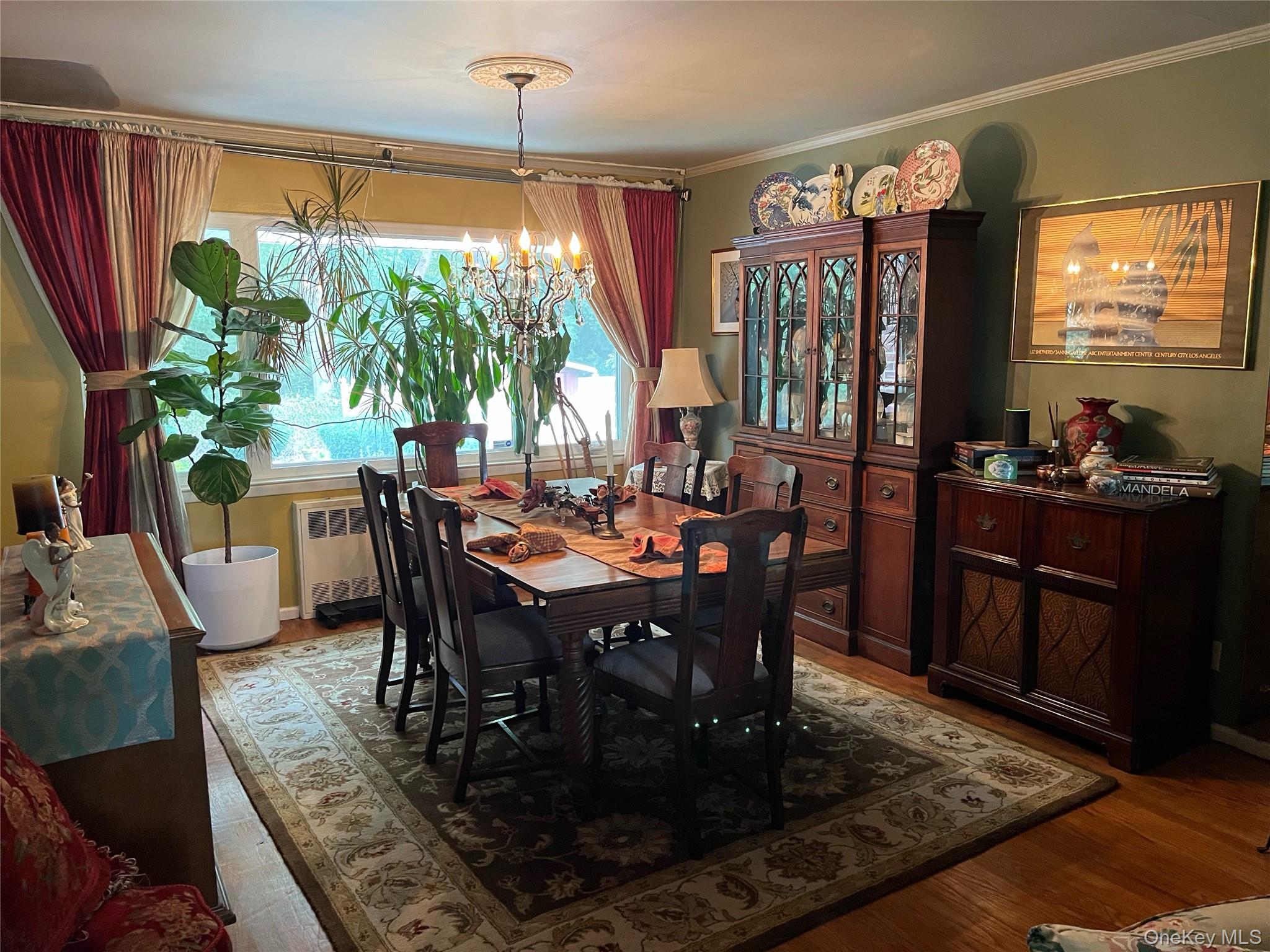 24 Cedar Road Westbury, NY 11590 - Photo 5 of 21 Dining room with radiator, a chandelier, wood finished floors, and ornamental molding