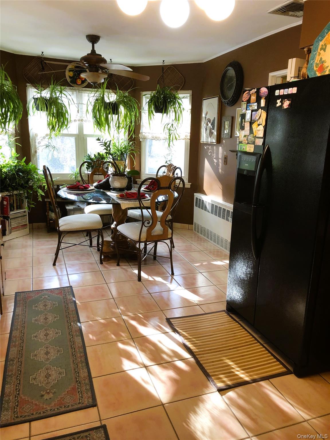 24 Cedar Road Westbury, NY 11590 - Photo 8 of 21 Dining room featuring light tile patterned floors, radiator, and ceiling fan