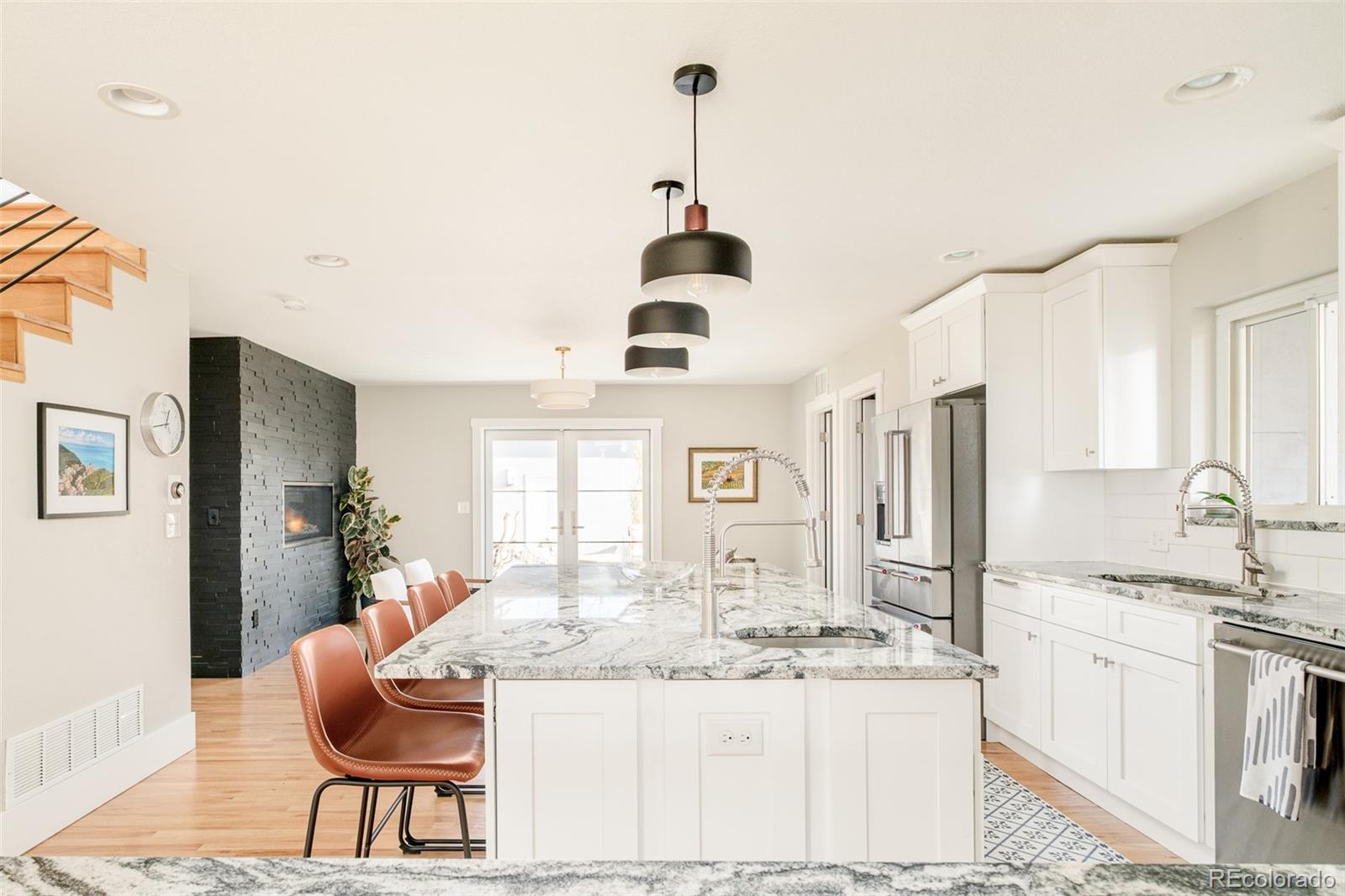a kitchen with stainless steel appliances kitchen island granite countertop a sink and a refrigerator