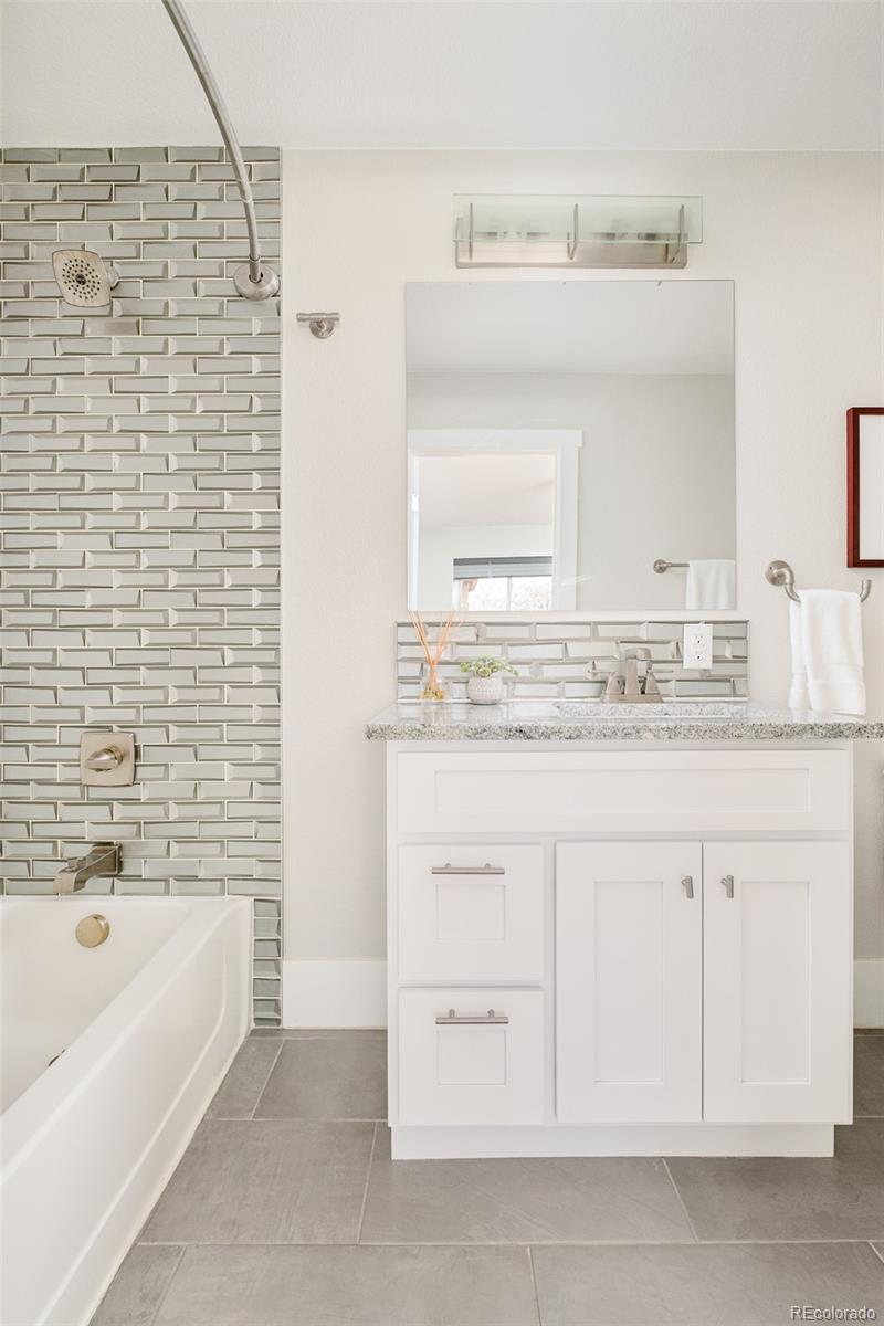 2048 Meade Street Denver, CO 80211 - Photo 17 of 50 a bathroom with a granite countertop sink mirror and bathtub