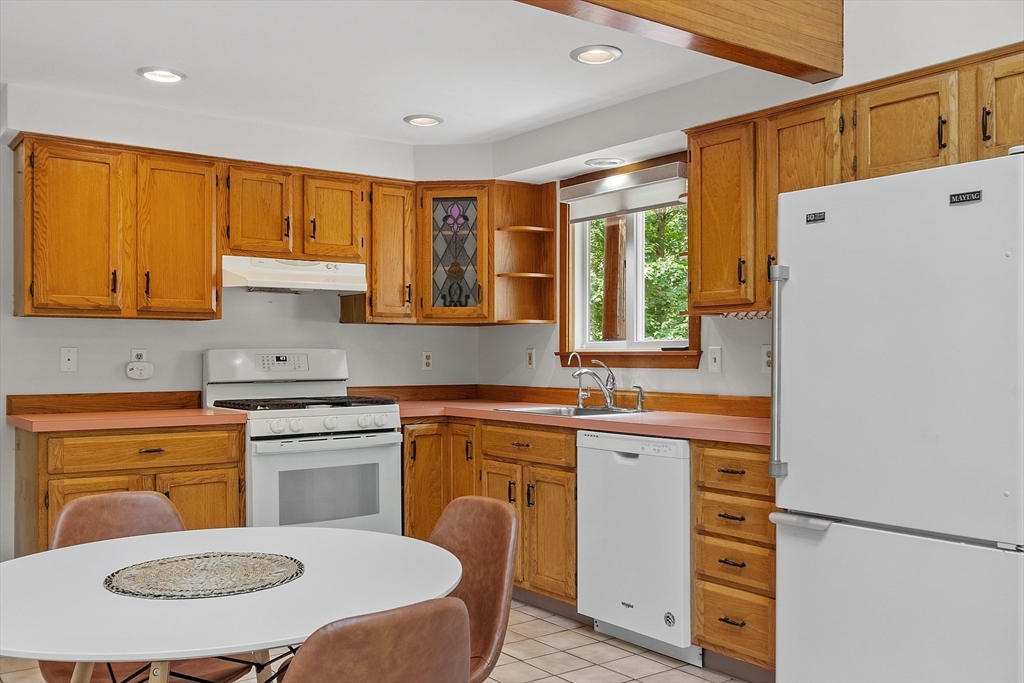 14 Boat House Road Groton, MA 01450 - Photo 13 of 41 a kitchen with a stove a sink a refrigerator and wooden cabinets