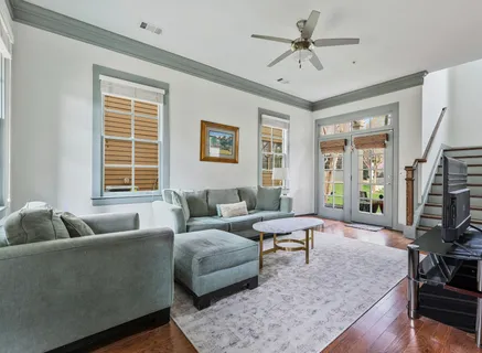 a living room with furniture floor to ceiling window and a flat screen tv