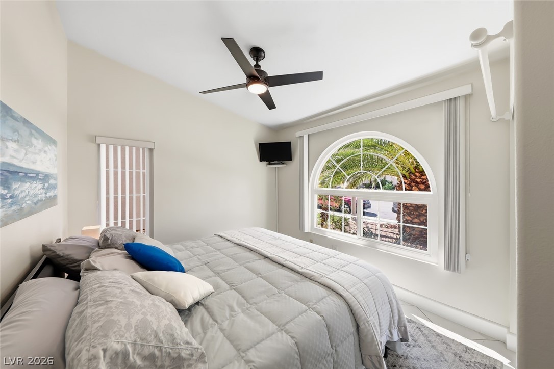 10 Rising Sun Court Henderson, NV 89074 - Photo 25 of 38 2nd bedroom with beautiful arch shaped window and ceiling fan.