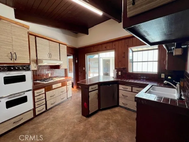 a kitchen with granite countertop a stove sink and microwave