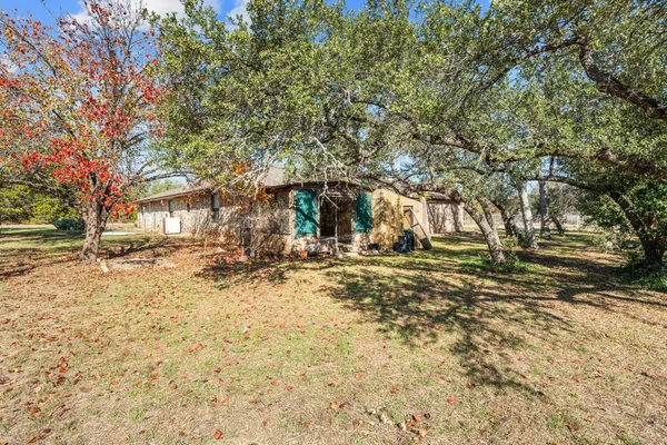 a view of backyard of house with green space