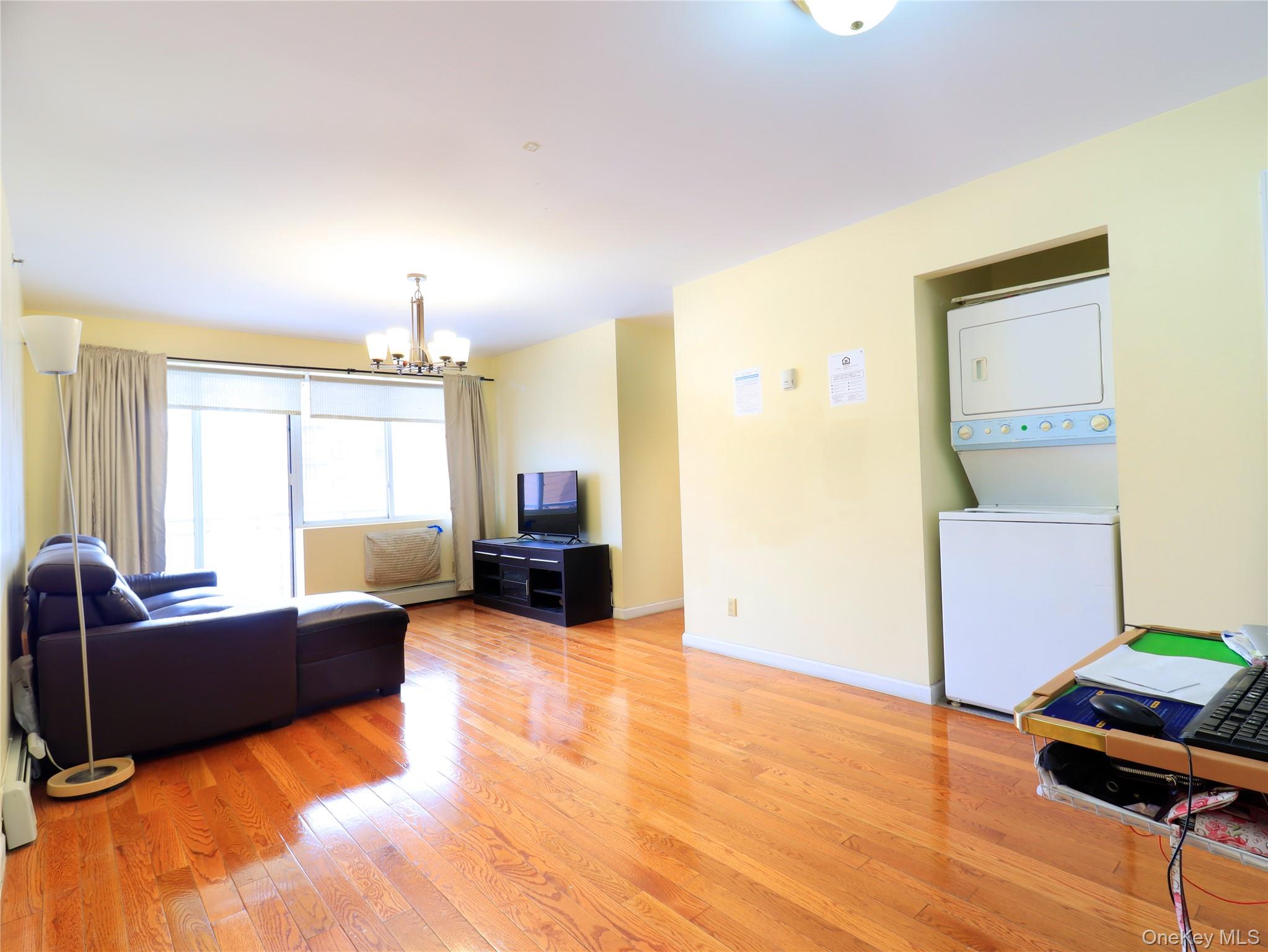 137-08 31st Road, Unit 5E Queens, NY 11354 - Photo 9 of 14 a living room with furniture and a flat screen tv