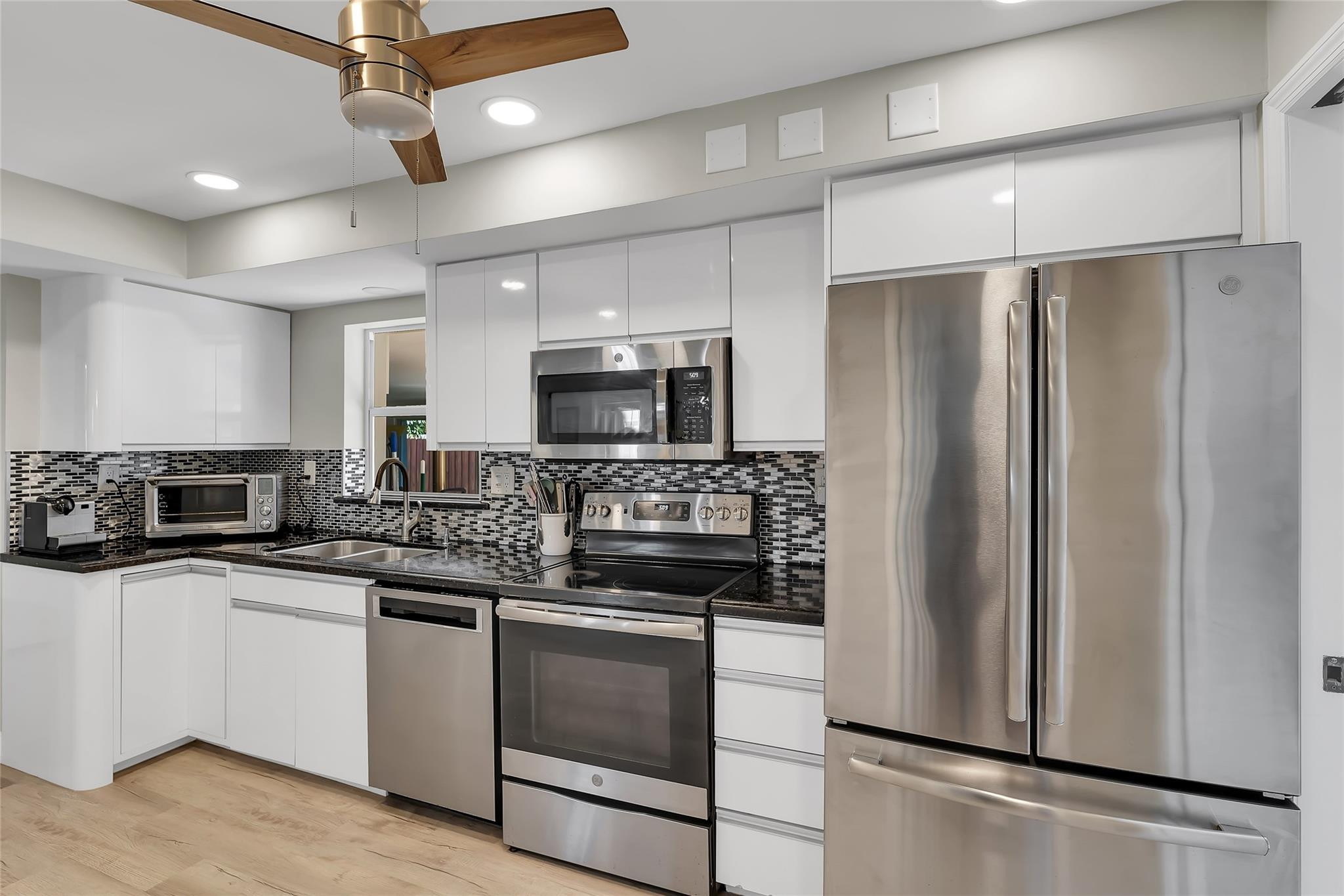 3404 Barton Road Pompano Beach, FL 33062 - Photo 17 of 46 a kitchen with a sink stainless steel appliances and cabinets