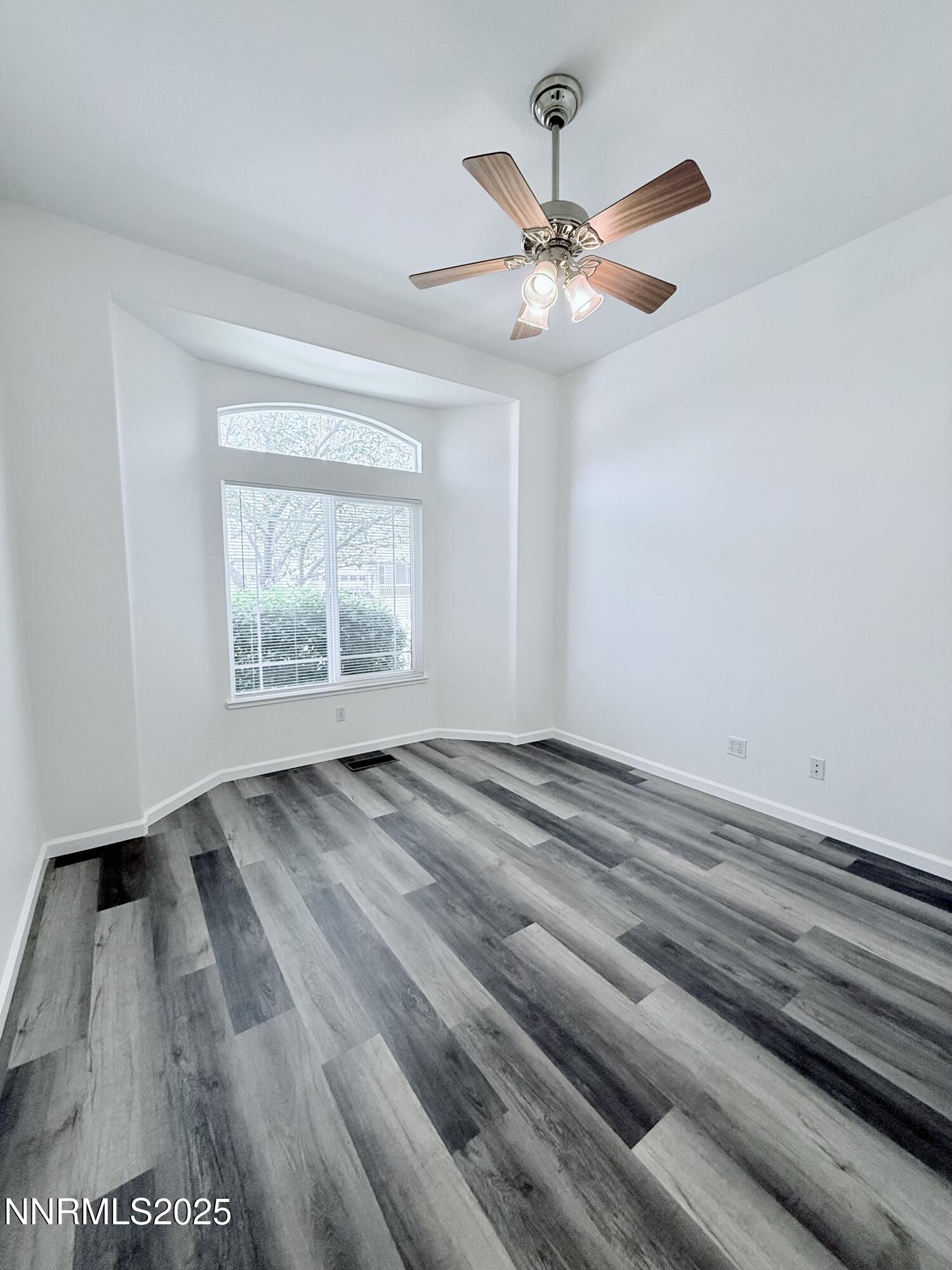 7539 Michaela Drive Reno, NV 89511 - Photo 27 of 33 an empty room with wooden floor fan and windows