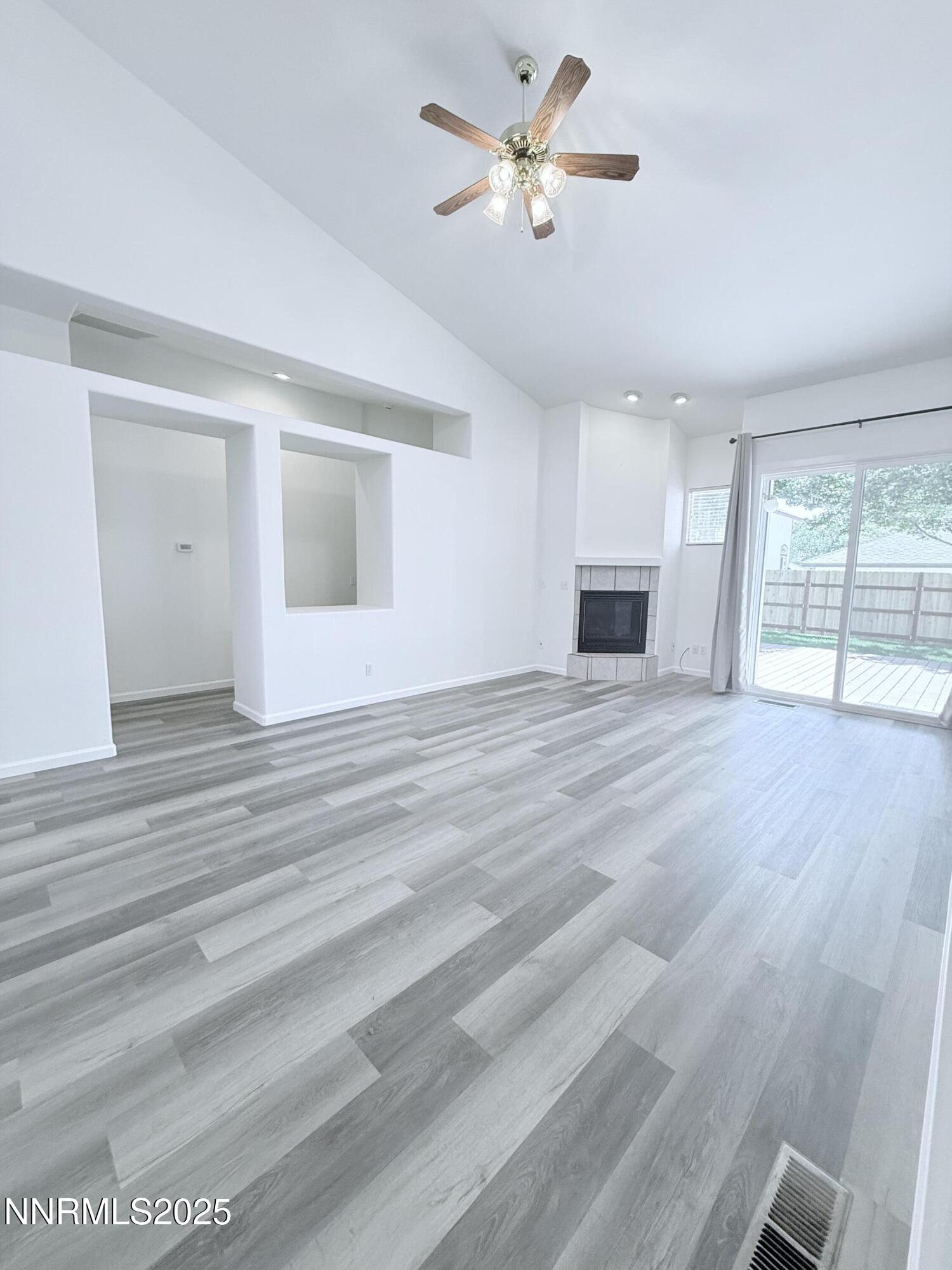 7539 Michaela Drive Reno, NV 89511 - Photo 8 of 33 an empty room with wooden floor and chandelier fan