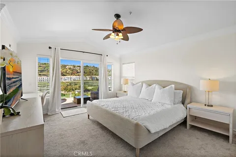 a bedroom with a bed and a flat tv screen on dresser