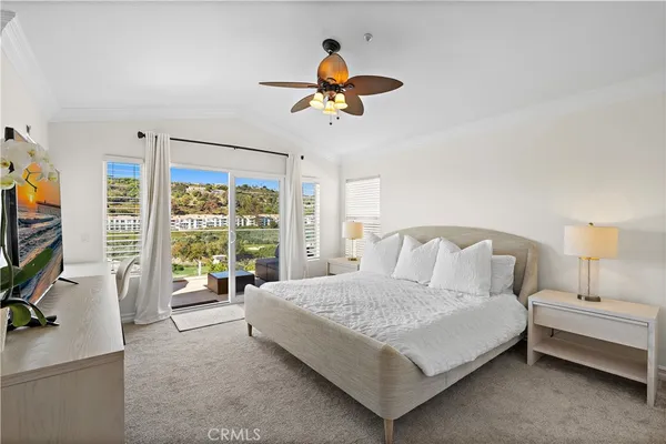 a bedroom with a bed and a flat tv screen on dresser