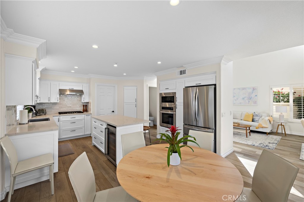 23 Cassis Dana Point, CA 92629 - Photo 6 of 19 a kitchen with stainless steel appliances granite countertop a refrigerator a stove a sink a dining table and chairs with wooden floor