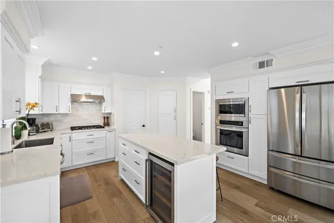 a large kitchen with stainless steel appliances and white cabinets