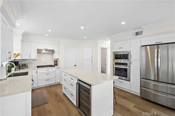 a large kitchen with stainless steel appliances and white cabinets