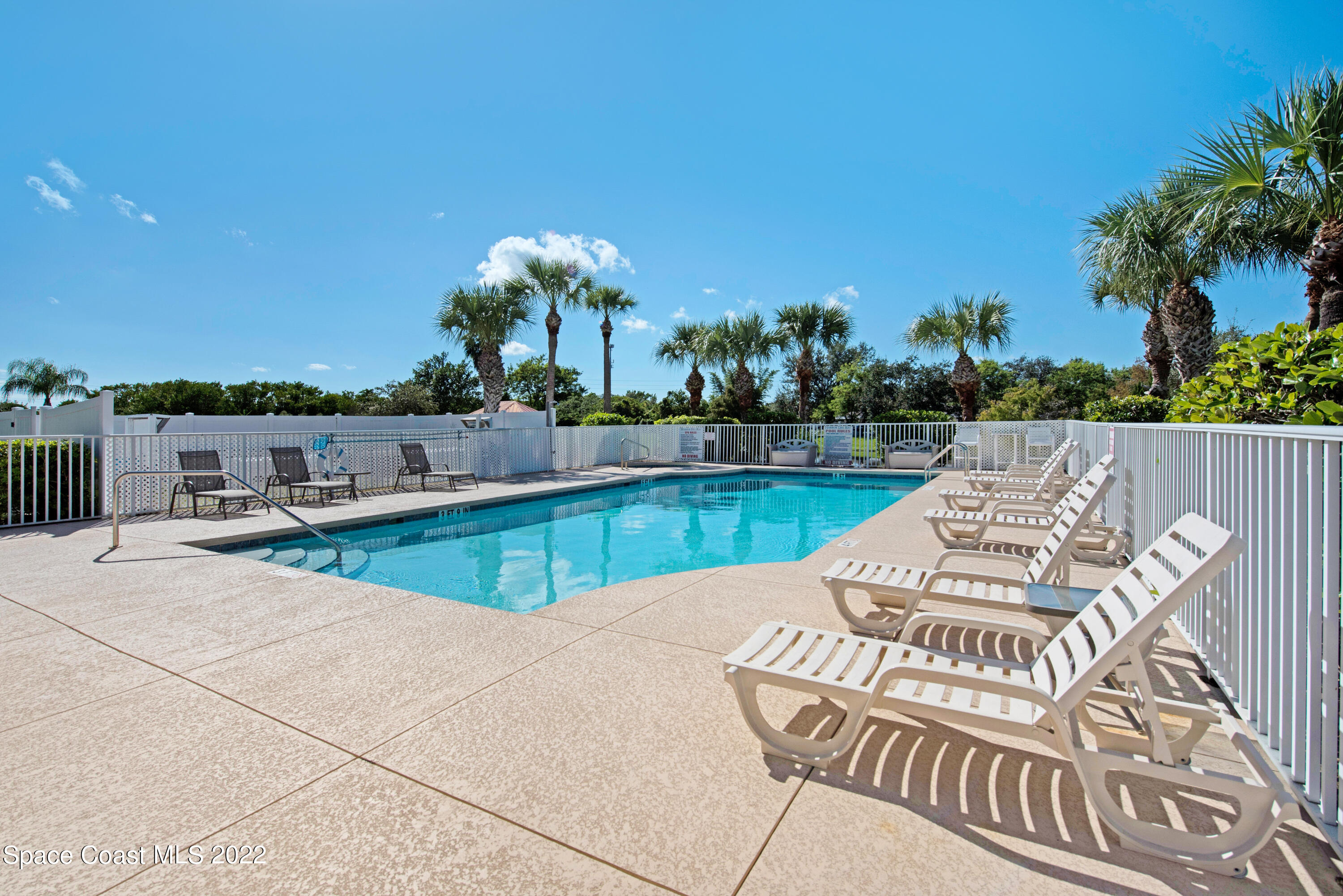 801 Del Rio Way, Unit 602 Merritt Island, FL 32953 - Photo 31 of 36 a view of swimming pool with seating space and trees in the background